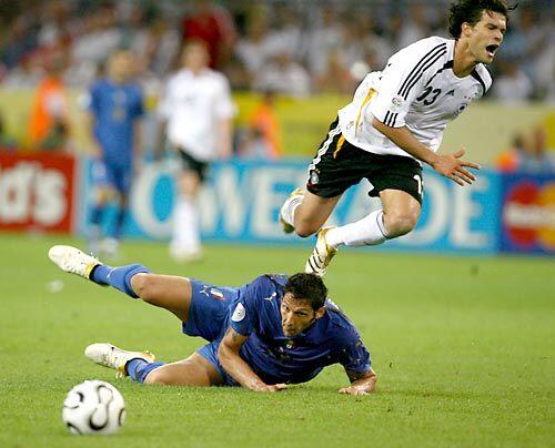 German midfielder Michael Ballack, right, jumps over Italian defender Marco Materazzi.