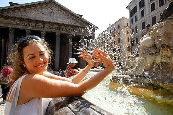 A woman splashes herself with water from a fountain. A heat-wave warning was issued for a number of Italian cities where temperatures were expected to reach or even surpass 104 degrees this week.