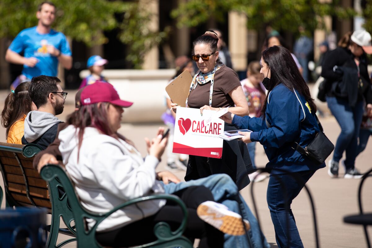 Valerie Traina and Trisha Tahmasbi, both volunteers of California Nurses Association, speak to people about CalCare.
