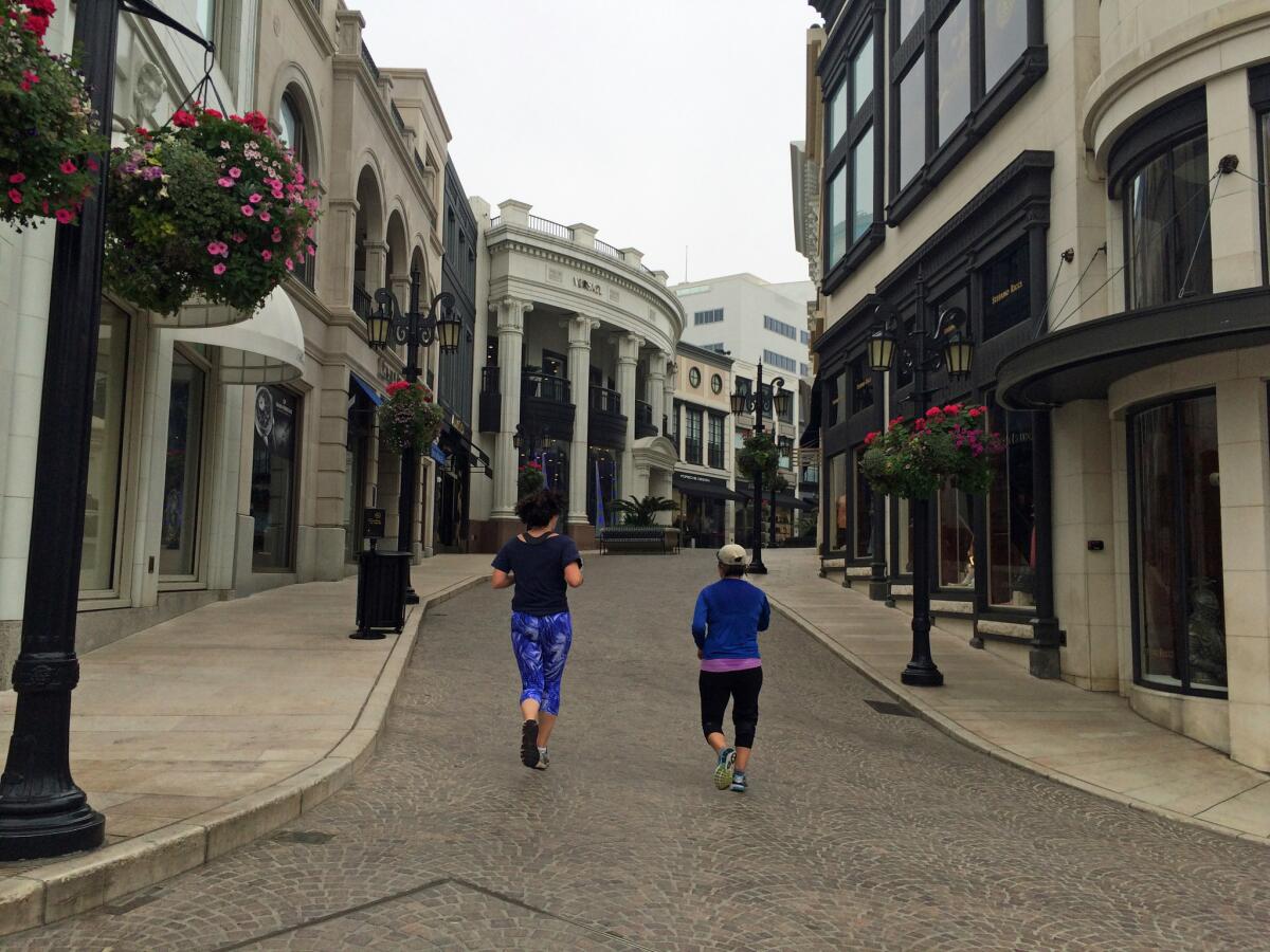 Abbie Swanson, left, and Maria Fellow running along Rodeo Drive in Beverly Hills early on a February morning.