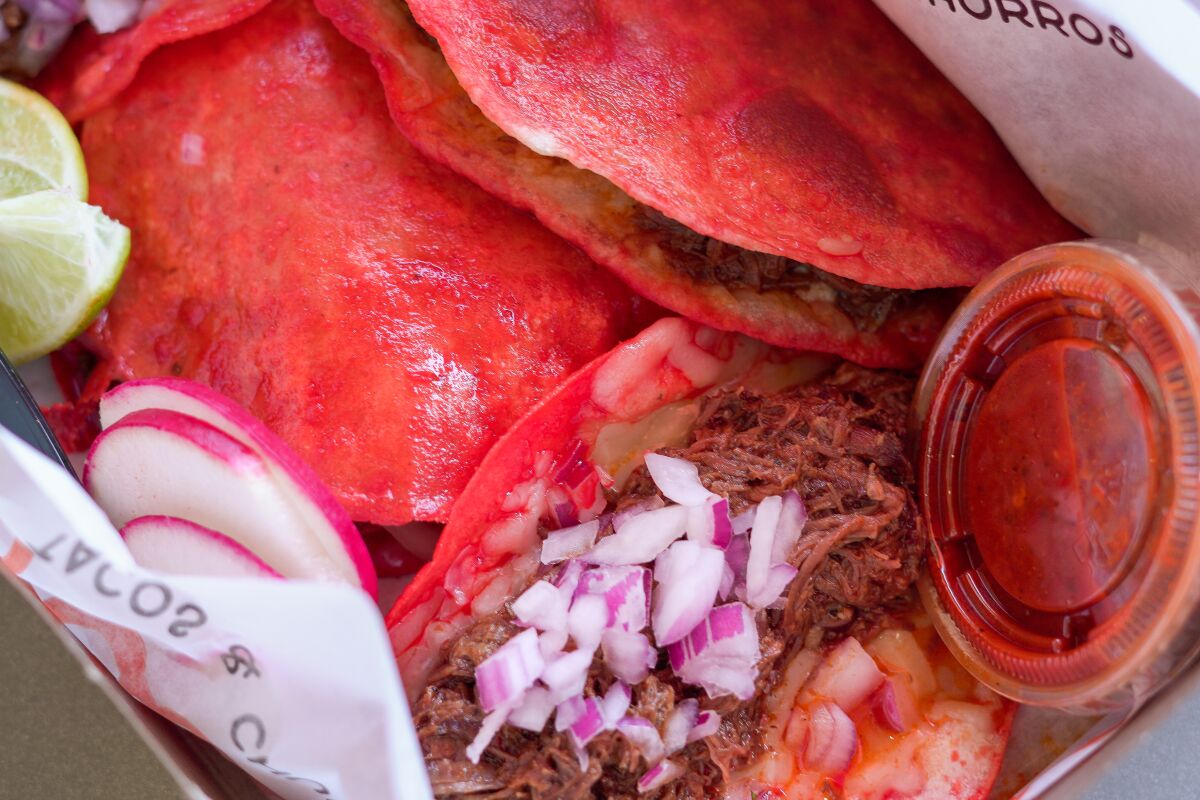 Papi's birria tacos are a distinctive shade of orange-red.