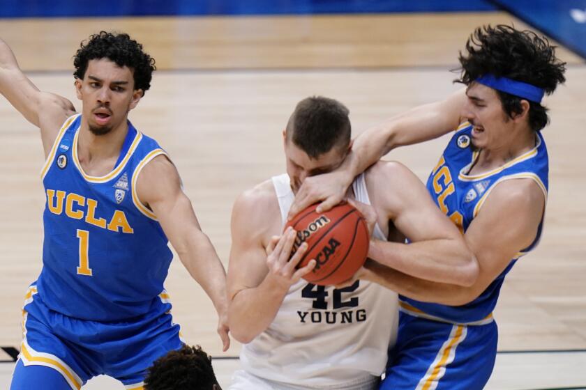 BYU guard Brandon Averette (4) battles for the ball with UCLA guard Jaime Jaquez Jr., right, as UCLA guard Jules Bernard (1) closes in during the first half of a first-round game in the NCAA college basketball tournament at Hinkle Fieldhouse in Indianapolis, Saturday, March 20, 2021. (AP Photo/AJ Mast)