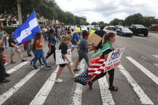Manifestantes cruzan una calle, el jueves 1 de junio de 2023, en Orlando, Florida, durante una protesta contra la nueva ley de inmigración de Florida que promulgó el gobernador Ron DeSantis. (Joe Burbank/Orlando Sentinel via AP)