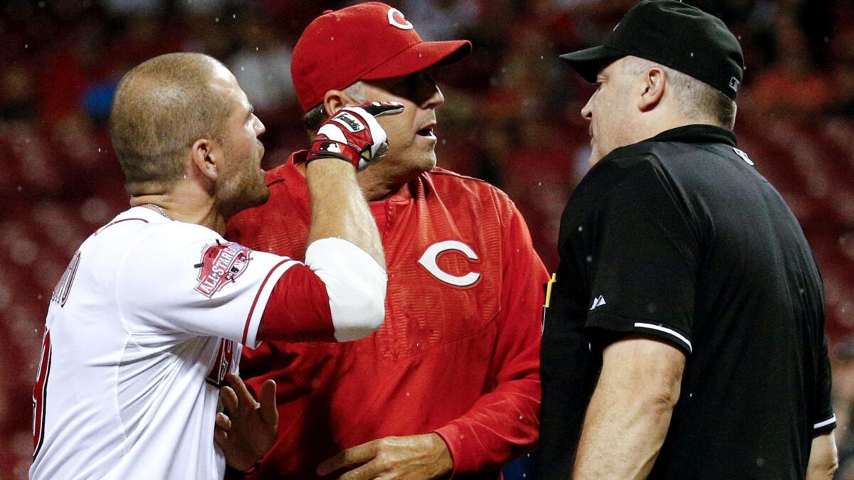 Reds first baseman Joey Votto, left, is separated from umpire Bill Welke, right, by Manager Bryan Price after Votto was ejected from the game on Wednesday night in Pittsburgh.