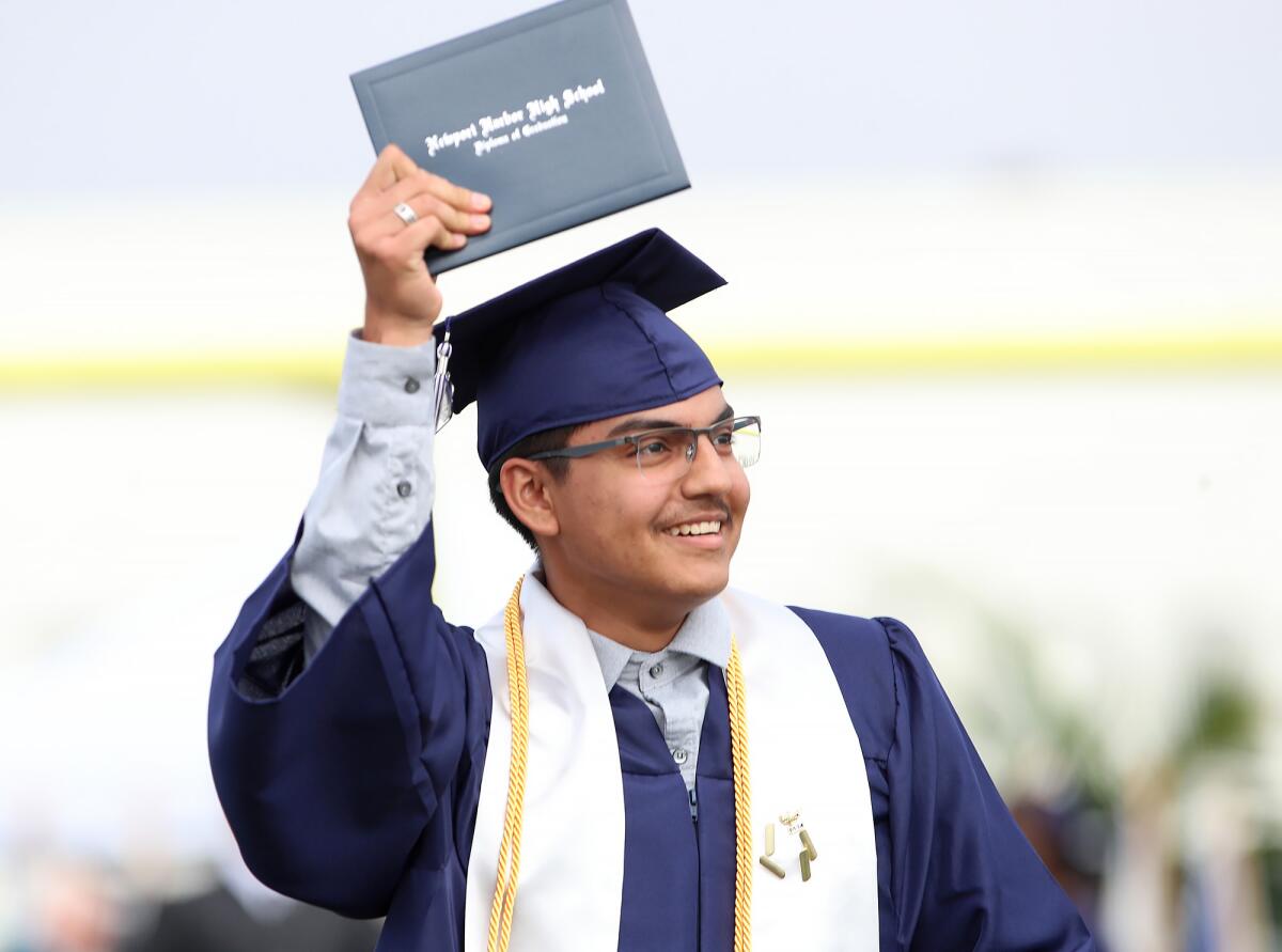 Nicholas Dante Mite happily shows his diploma to family during the 93rd annual Newport Harbor graduation on Thursday.
