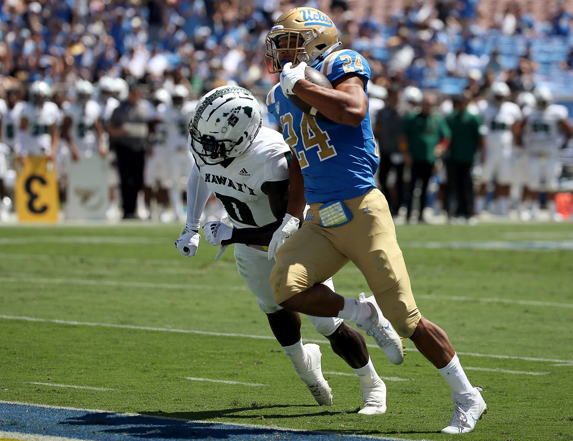 UCLA running back Zach Charbonnet gets past Hawaii safety Chima Azunna to score a touchdown in the second quarter.