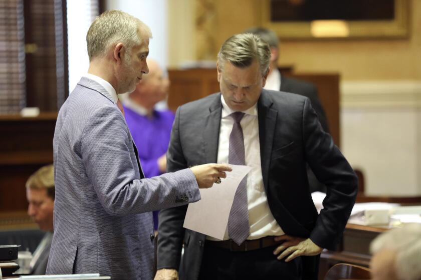South Carolina Sen. Michael Johnson, R-Fort Mill, left, talks to Sen. Tom Davis, R-Beaufort, as the Senate debates whether to ban gender-affirming care for transgender minors was this in Columbia, S.C., Wednesday, May 2, 2024. (AP Photo/Jeffrey Collins)