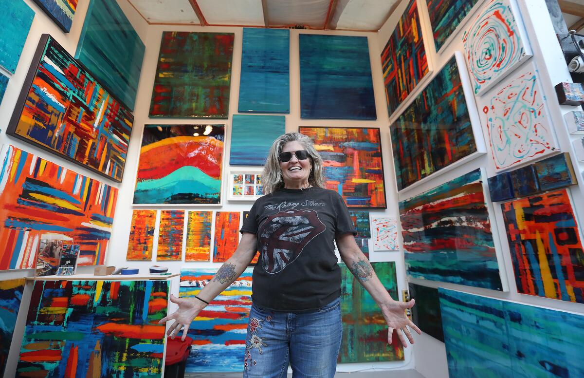 Fine artist Suzanne Graham welcomes guests to her booth during the 2022 Sawdust Festival preview night in Laguna Beach.