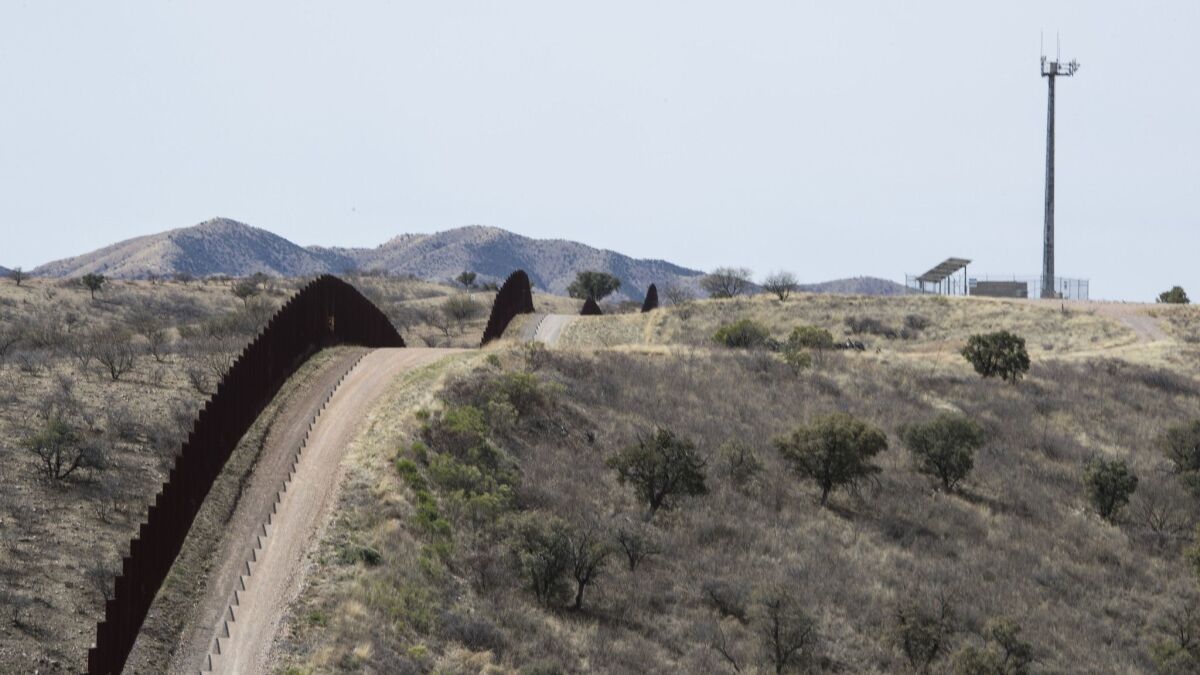 A fence traces along the U.S-Mexico border near Nogales, Ariz.
