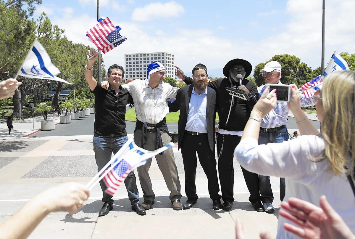 Supporters dance around Rabbi Zevi Tenenbaum, of the Rohr Chabad at UC Irvine, and Rabbi Blue, holding the microphone, during a pro-Israel rally Thursday at UC Irvine.
