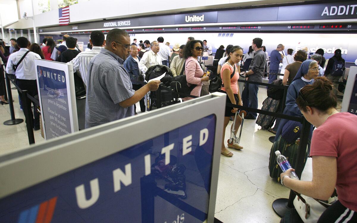 Passengers wait in line to check in for United Airlines flights at Los Angeles International Airport in 2007. United is outsourcing more than 600 positions at 12 airports and adding about 400.