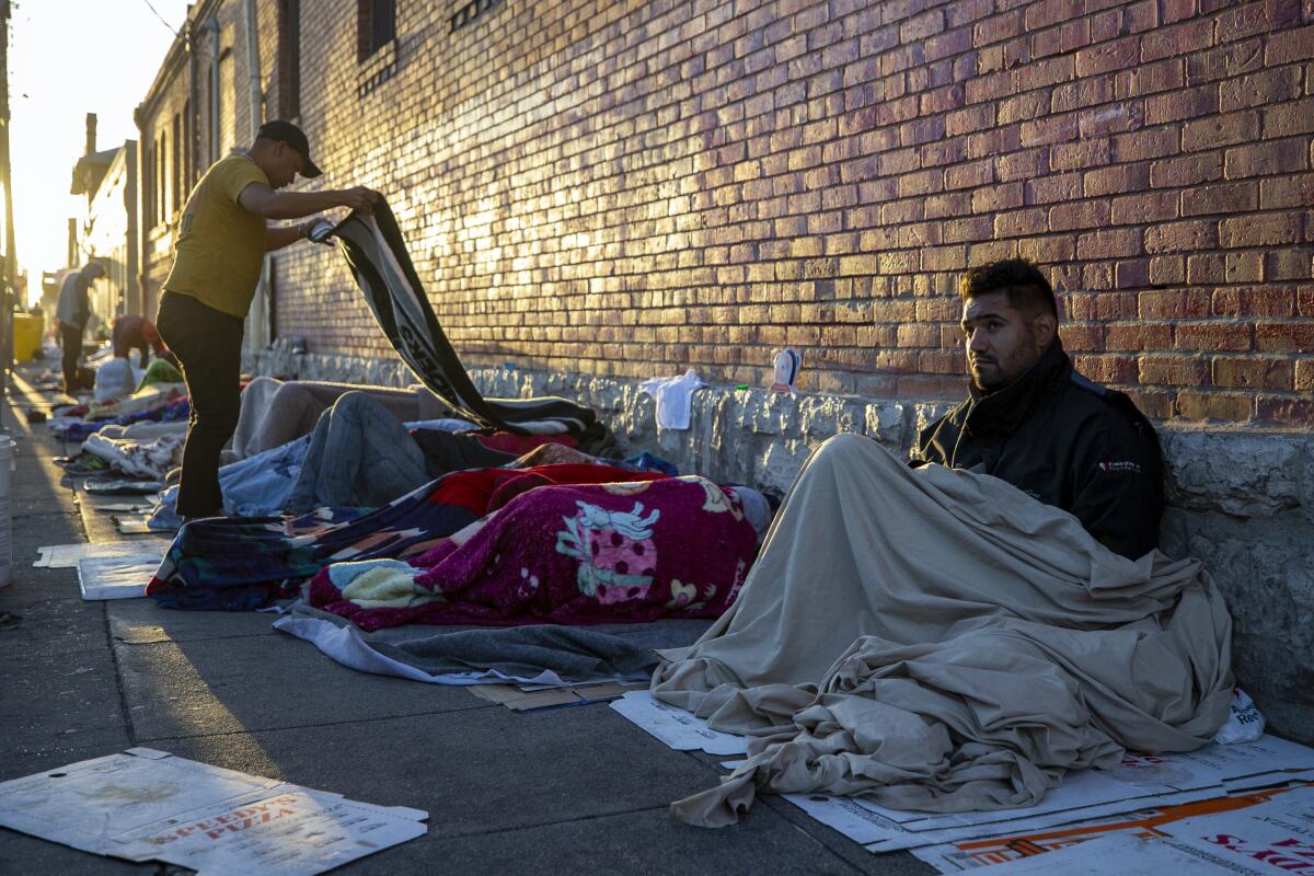 Migrants wake up at the campsite outside Sacred Heart Church in downtown El Paso, Texas, in May.