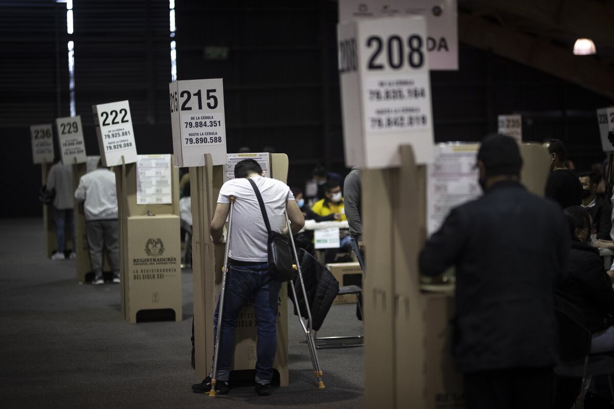 People cast their votes during legislative elections in Bogota, Colombia, Sunday, March 13, 2022. Colombians went to the polls to renew Congress, and also to choose presidential candidates from three political coalitions whose outcome will be key for the next presidential election on May 29. (AP Photo/Ivan Valencia)