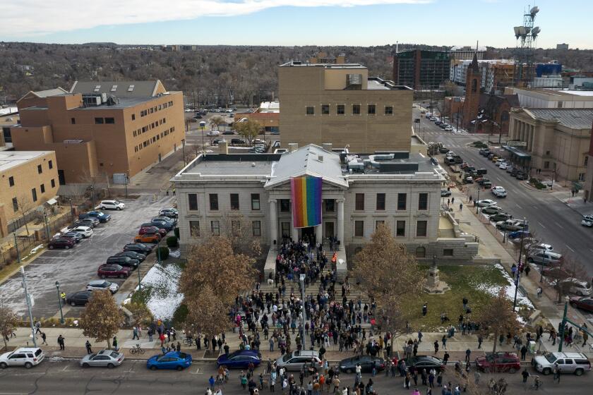 In this aerial image taken with a drone, a rainbow flag is unfurled at City Hall Wednesday, Nov. 23, 2022, in Colorado Springs, Colo. With a growing and diversifying population, the city nestled at the foothills of the Rockies is a patchwork of disparate social and cultural fabrics. But last weekend’s shooting has raised uneasy questions about the lasting legacy of cultural conflicts that caught fire decades ago and gave Colorado Springs a reputation as a cauldron of religion-infused conservatism, where LGBTQ people didn't fit in with the most vocal community leaders' idea of family values (AP Photo/Brittany Peterson)