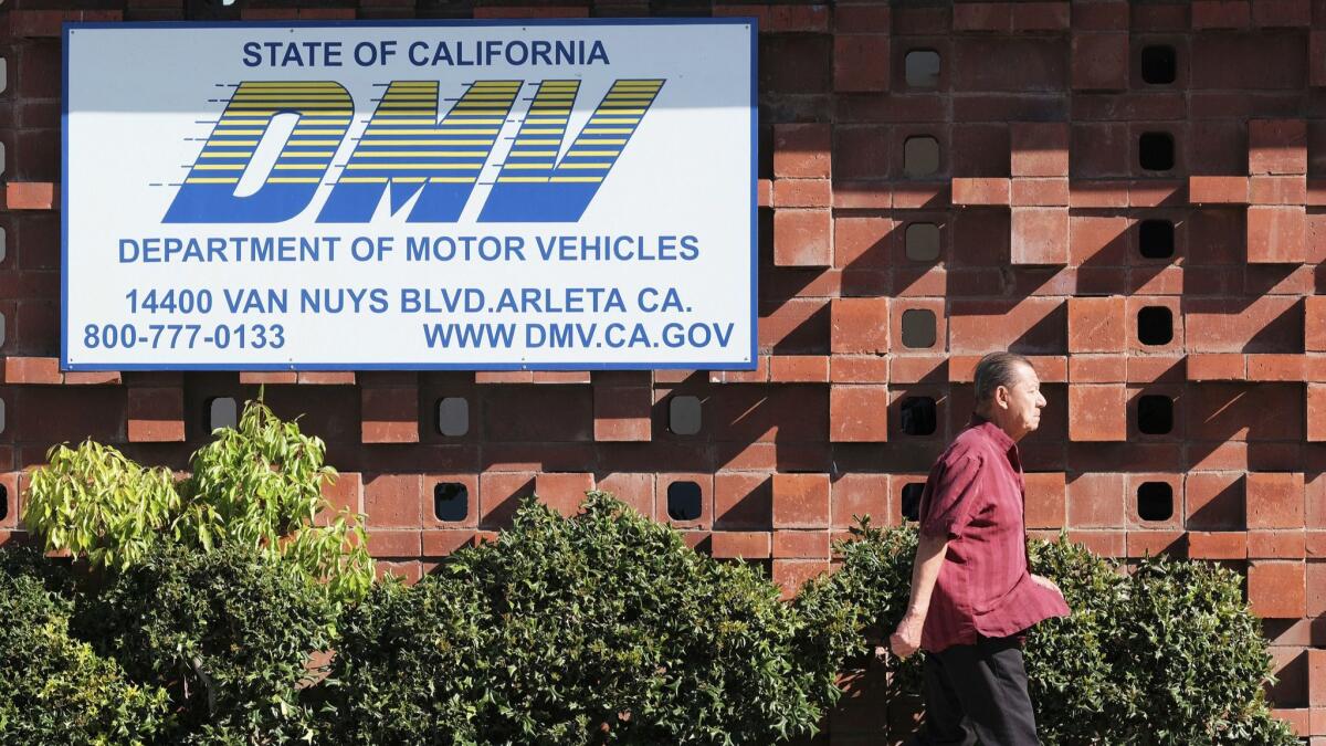 A man passes a California Department of Motor Vehicles office in the Arleta neighborhood of Los Angeles Tuesday, April 9.