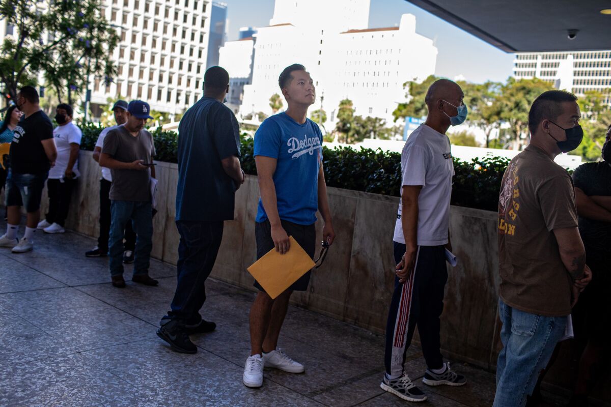 Justin Chung waits in line to get into a federal building in Los Angeles, where he checks in with immigration agents.