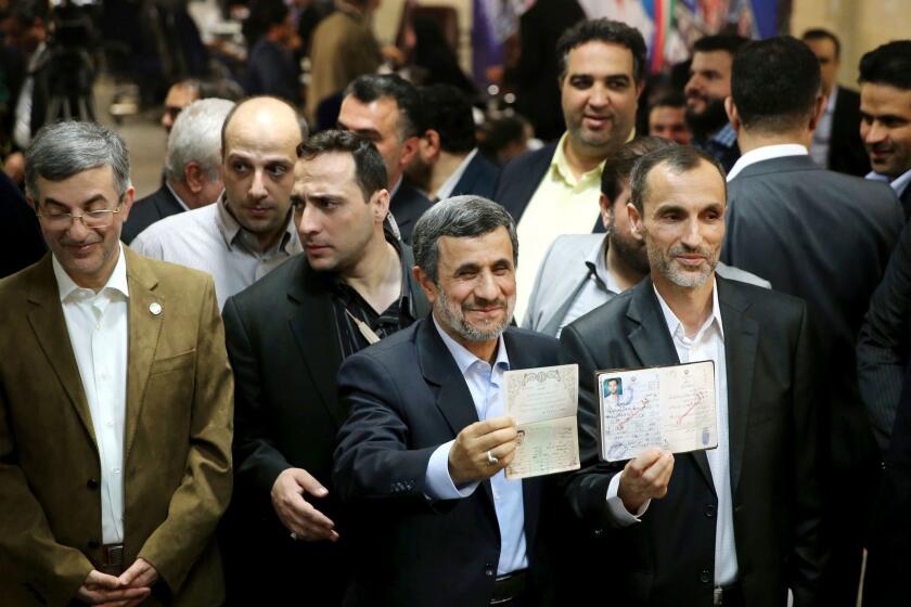 Former Iranian President Mahmoud Ahmadinejad, center, and his close ally Hamid Baghaei, right, show their identifications after registering their candidacy for the upcoming presidential elections at the Interior Ministry to , in Tehran, Iran, Wednesday, April 12, 2017. Ahmadinejad on Wednesday unexpectedly filed to run in the country's May presidential election, contradicting a recommendation from the supreme leader to stay out of the race. Other close ally of Ahmadinejad, Esfandiar Rahim Mashie accompanies them. (AP Photo/Ebrahim Noroozi)