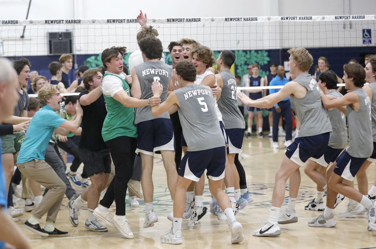 Students rush the court to celebrate with the Newport Harbor boys' volleyball team.
