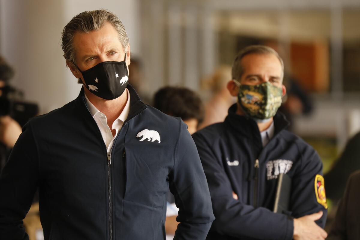 California Gov. Gavin Newsom, left, and L.A. Mayor Eric Garcetti at a COVID-19 vaccination site at Cal State L.A. on Feb. 16