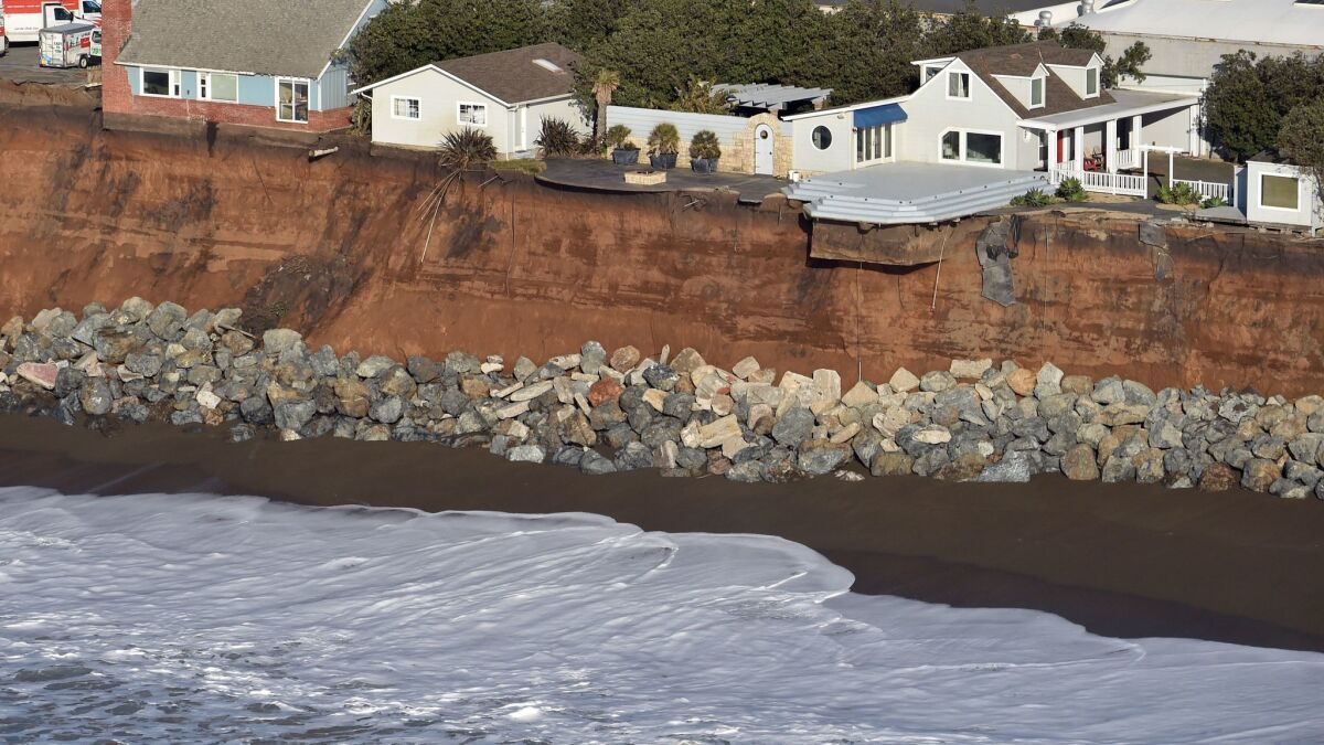 Houses hang on the edge of an eroding cliff in Pacifica, Calif.