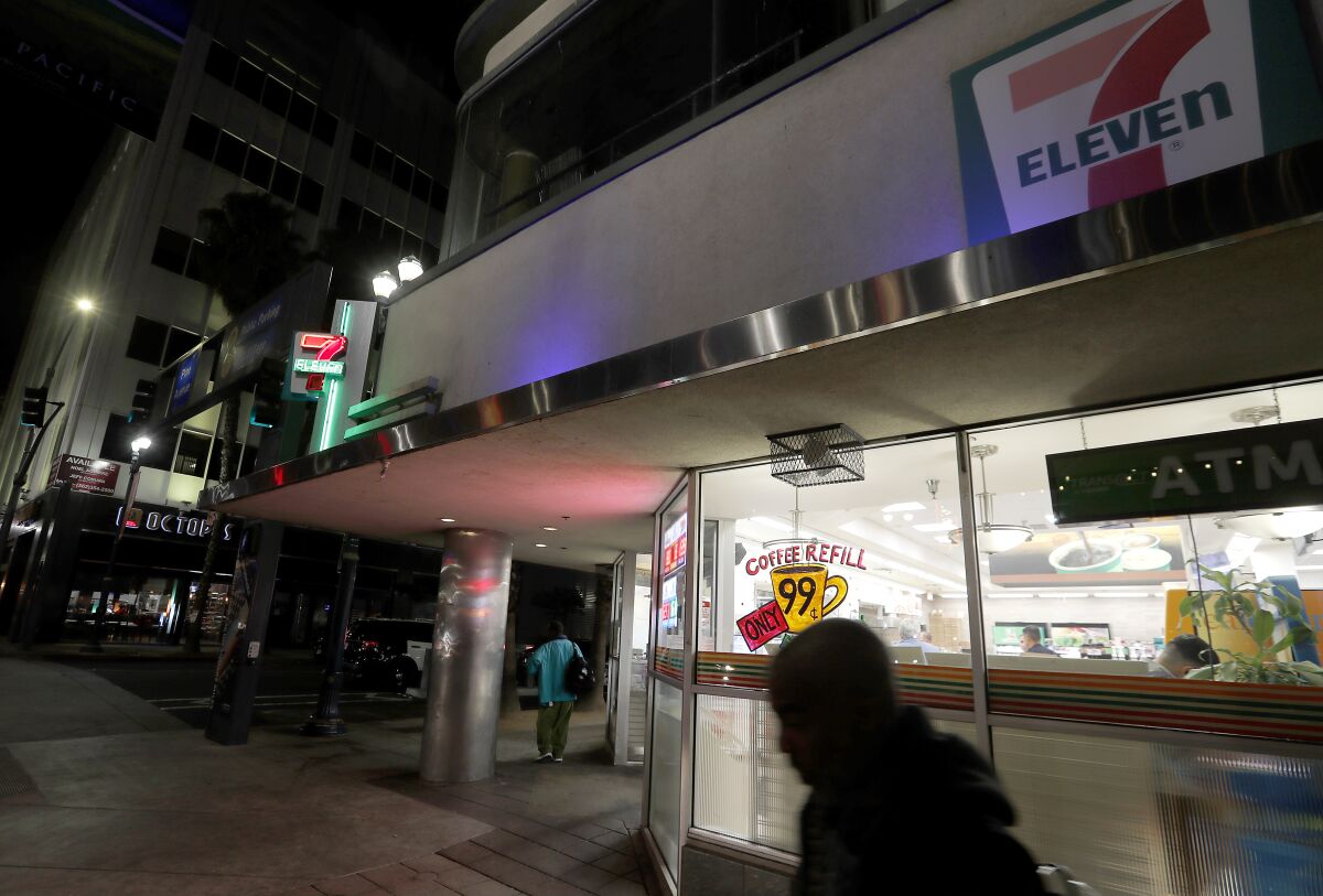 Homeless men mill around outside a 7-Eleven store in Long Beach. 
