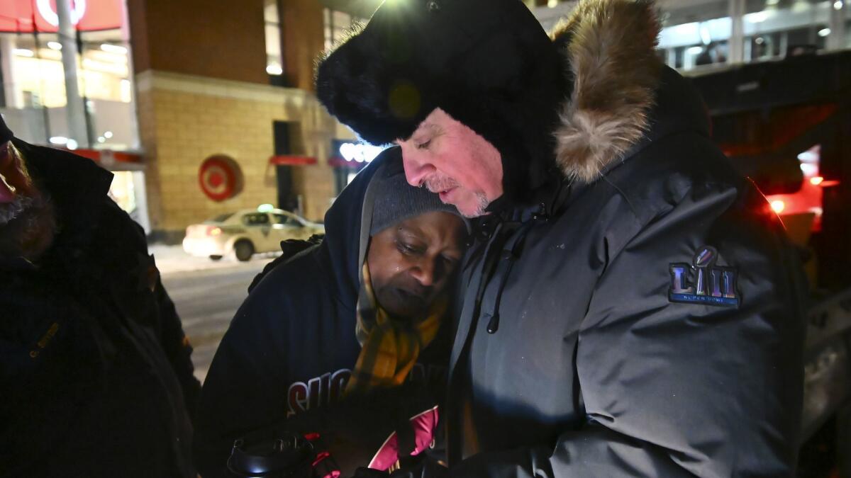 Pastor John Steger embraces Jearline Cyrus, a homeless woman, in downtown Minneapolis on Tuesday, while delivering cold-weather gear, hot chocolate and food.