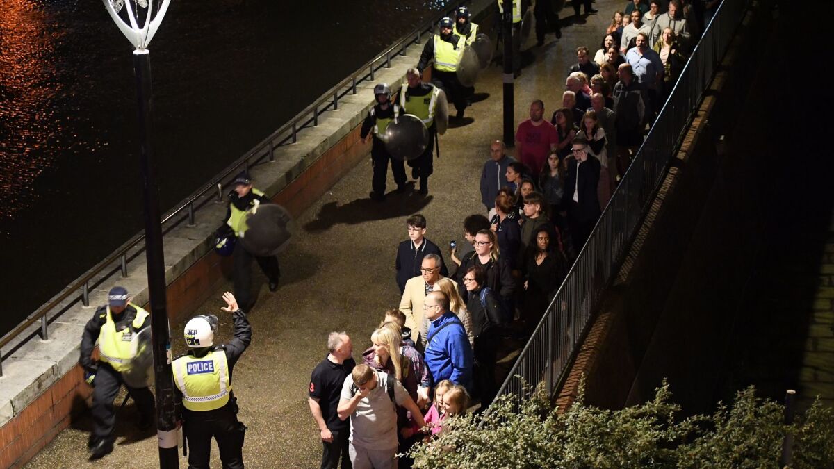 People are led to safety away from London Bridge shortly after police responded to reports of a van plowing into people on June 3.