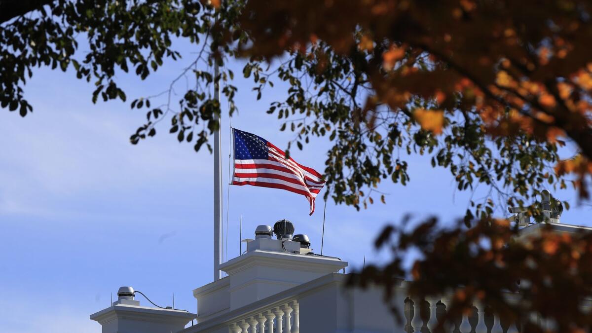 The American flag is lowered at half-staff at the White House in Washington, Thursday, Nov. 8, 2018, to honor the victims of the shooting at a bar in Thousand Oaks, Calif.