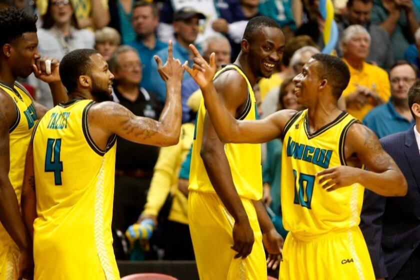 UNC Wilmington players celebrate on the bench after defeating College of Charleston to win the Colonial Athletic Association tournament on Mar. 6.