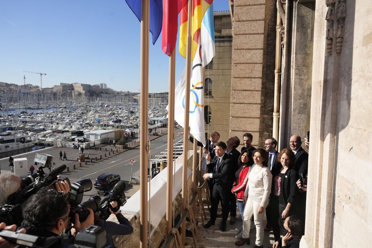 El alcalde de Marsella Benoit Payan eleva la bandera olímpica frente al director de París 2024 