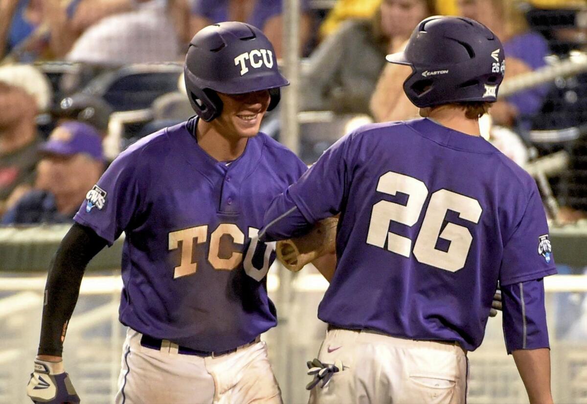 TCU's Connor Wanahanen, left, and Keaton Jones (26) after scoring on a single by Dane Steinhagen in the seventh inning of a College World Series game on Thursday in Omaha, Neb.