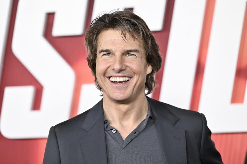 Tom Cruise smiles in dark grey suit at the July 2023 premiere of "Mission: Impossible - Dead Reckoning Part One" in New York