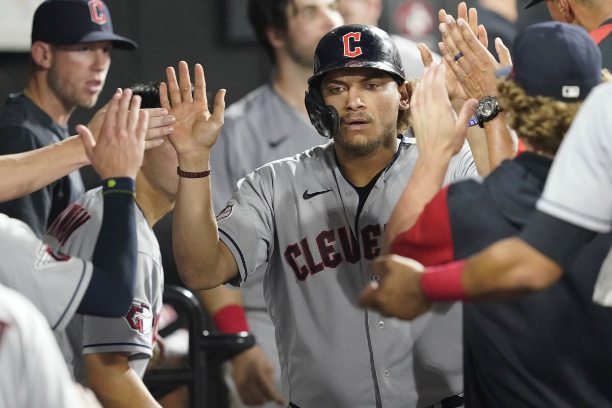 Cleveland Guardians' Josh Naylor celebrates his home run off Chicago White Sox starting pitcher Lucas Giolito in the dugout during the seventh inning of a baseball game, Tuesday, May 10, 2022, in Chicago. (AP Photo/Charles Rex Arbogast)