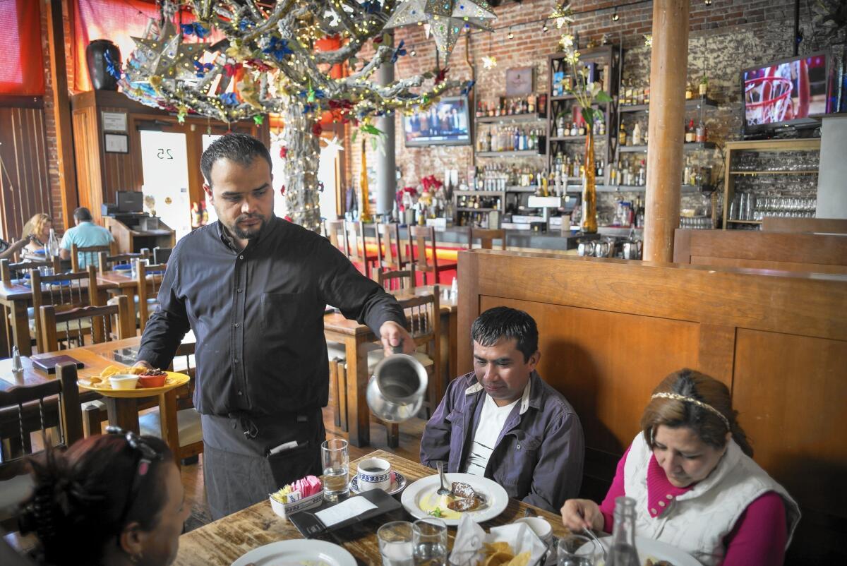 Mezcal, a Mexican restaurant in San Jose, decided to get by without a restaurant manager or a sous chef after a minimum wage hike from $8 to $10 an hour in 2013. Above, Pablo Macias serves customers at the restaurant this month.