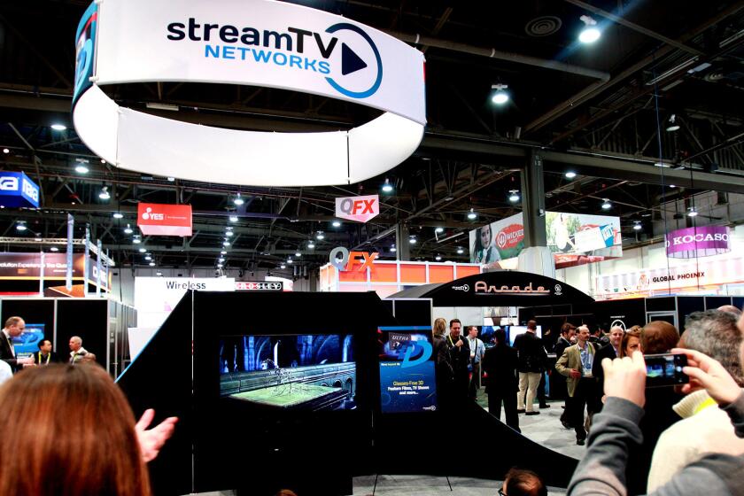 A crowd gathers to view streamTV Network's Ultra-D glasses-free 3D technology that is installed in ultra-HD TVs.