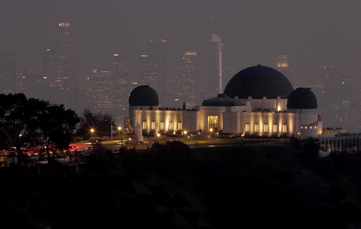 The Griffith Observatory, lighted and seen from a distance, at dusk.