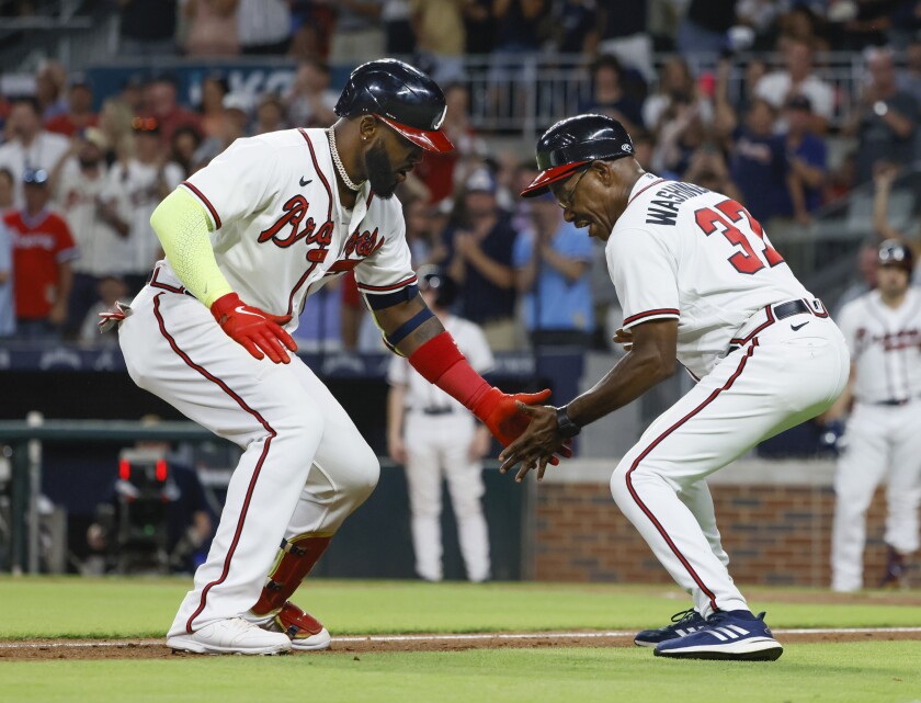 Atlanta Braves' Marcell Ozuna low-fives third base coach Ron Washington after he hit a two-run home run against the Los Angeles Dodgers during the eighth inning of a baseball game Saturday, June 25, 2022, in Atlanta. (AP Photo/Bob Andres)