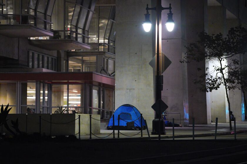 San Diego, CA - August 24: In the early evening hours on Wednesday, Aug. 24, 2022 in San Diego, CA., a few tents begin to setup for the night in front of San Diego Central Library. (Nelvin C. Cepeda / The San Diego Union-Tribune)