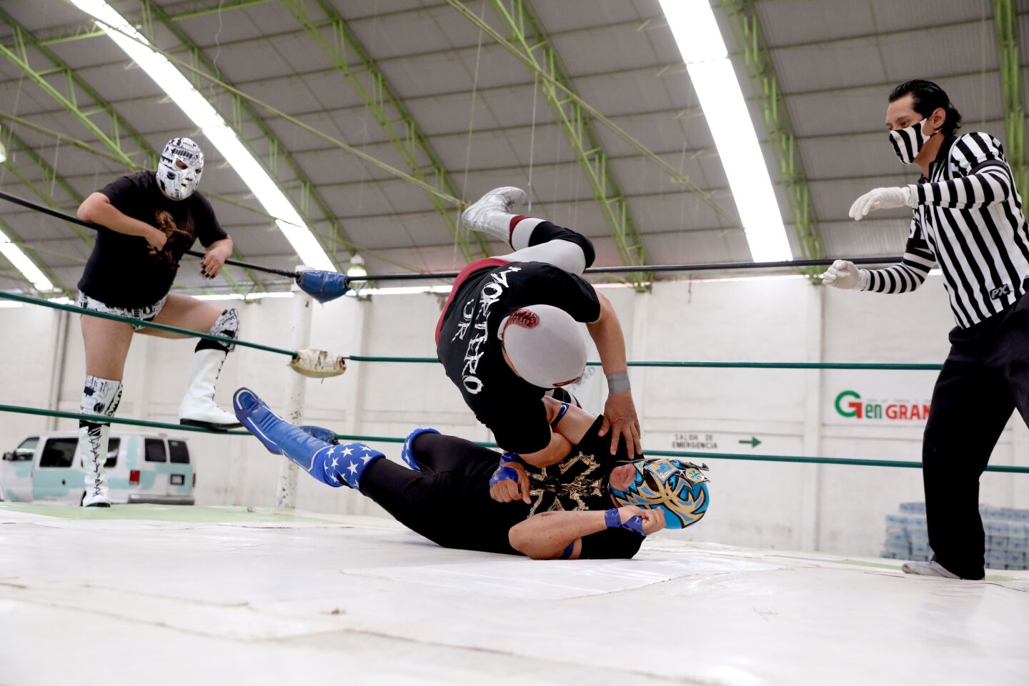 Referee Furcio keeps a close watch while wrestlers Tazosomok, from left, Mortero and Xtroh, on ground, battle it out.
