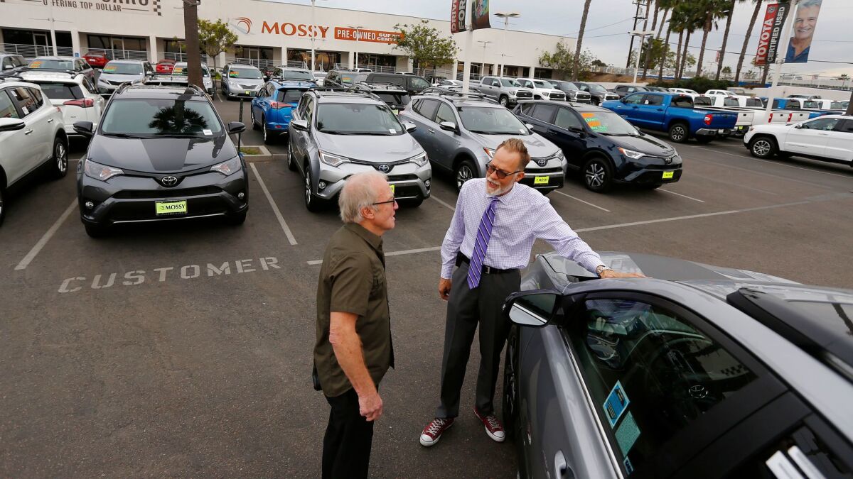 Salesman Rick Kitsmiller, right, shows off a Toyota Rav4 to customer Eric Jones at Mossy Toyota in Pacific Beach on Nov. 28, 2017. Light truck sales exceeded sales in cars in San Diego County and across California last year.