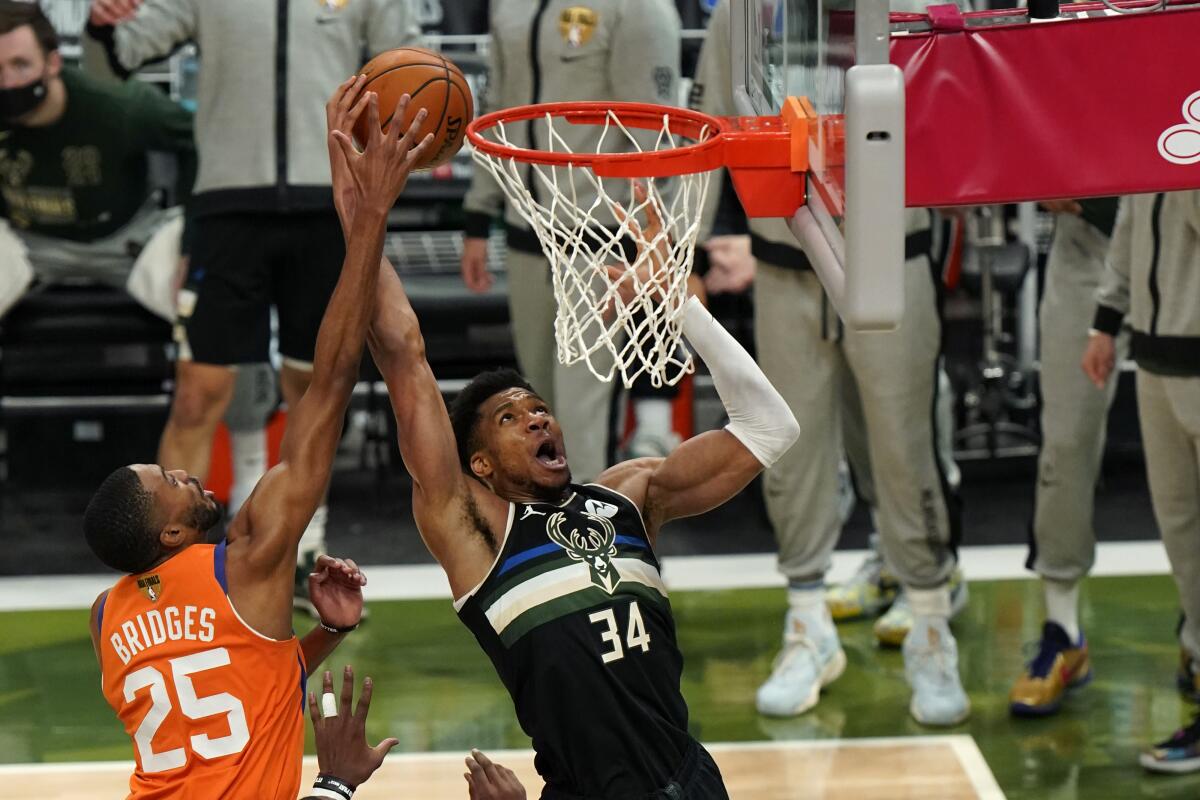 Milwaukee Bucks forward Giannis Antetokounmpo goes to the basket against Phoenix Suns forward Mikal Bridges.