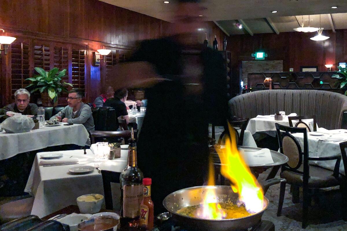 A waiter flames Steak Diane tableside at Dal Rae in Pico Rivera.