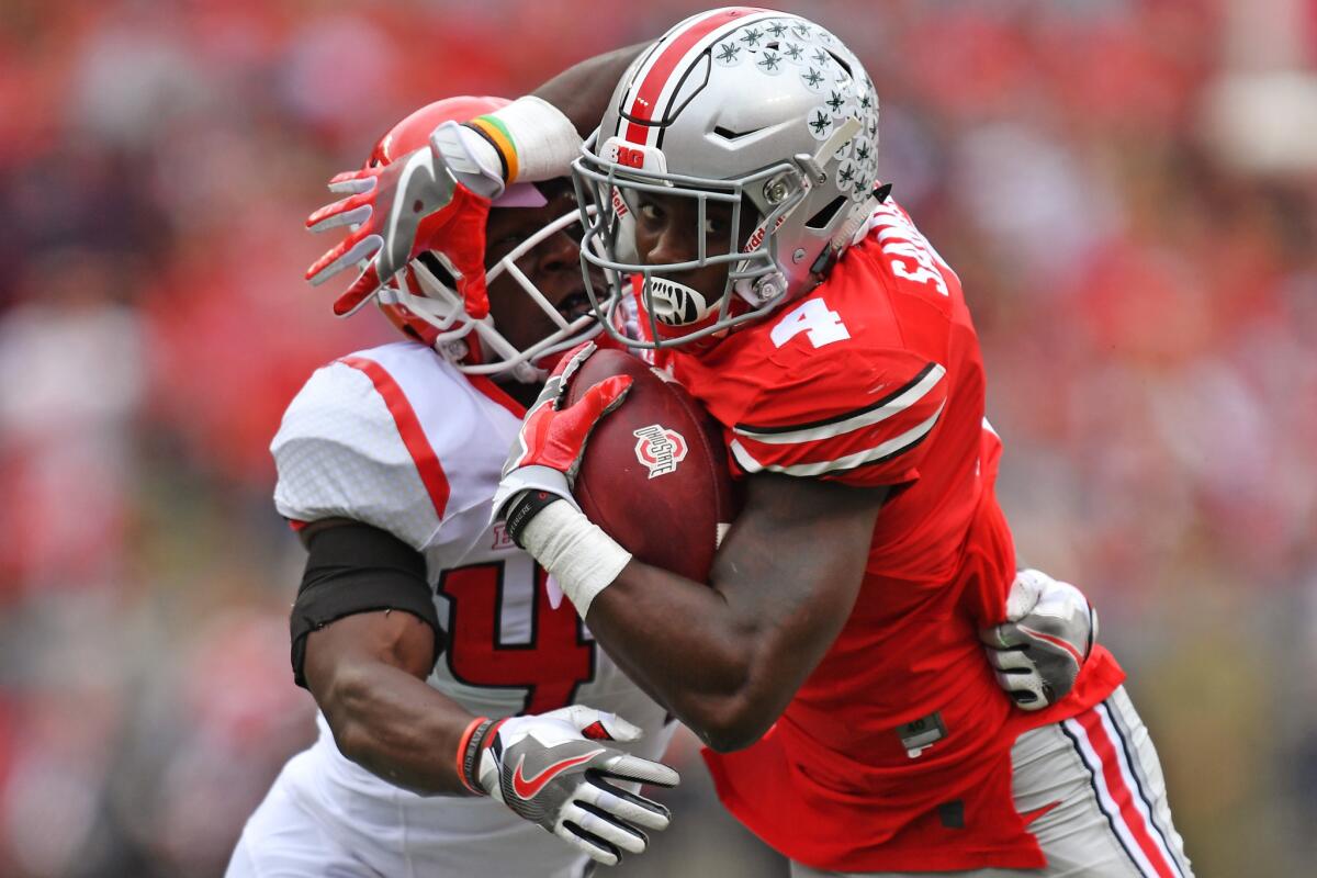 Ohio State running back Curtis Samuel (4) fights off a tackle attempt from Rutgers' Tyreek Maddox-Williams in the second quarter.