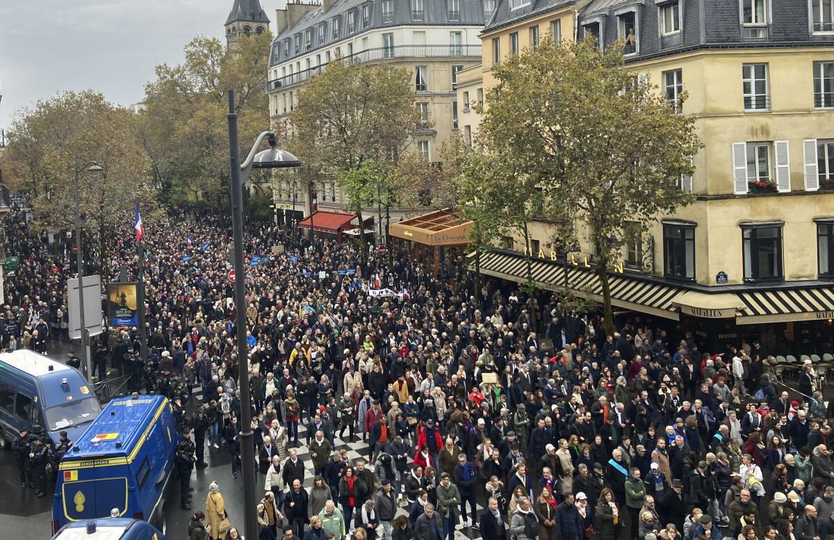 Marchers fill a wide street in Paris.