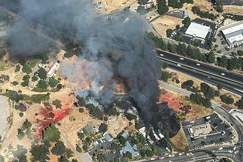 CAL FIRE firefighters responding to a vegetation fire in Grass Valley, Nevada County. Report of bushes on fire between Lumberjacks Restaurant and a Honda repair shop on Nevada City Highway. Air resources over the fire..