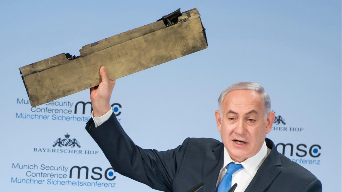 Israeli Prime Minister Benjamin Netanyahu holds what he said was part of a downed Iranian drone during his speech at the Munich Security Conference in Germany on Feb. 18, 2018.