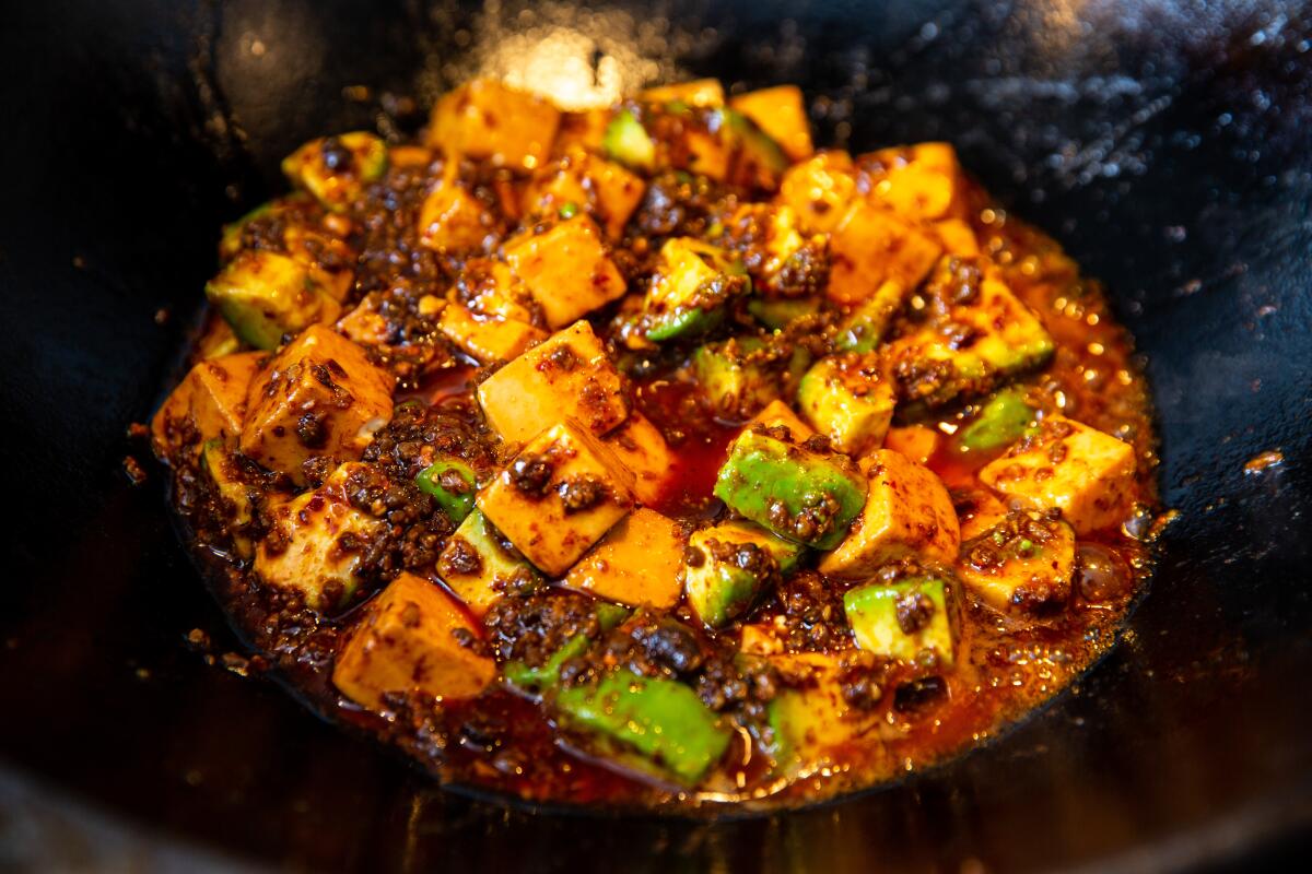 Avocado mapo tofu being cooked in the wok.