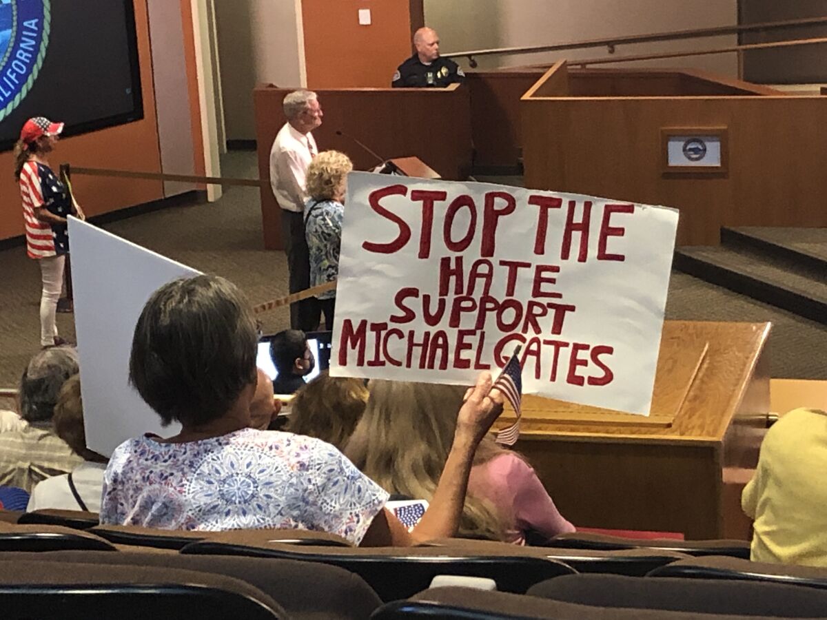 A woman holds a sign supporting Huntington Beach City Atty. Michael Gates during Tuesday night's meeting.