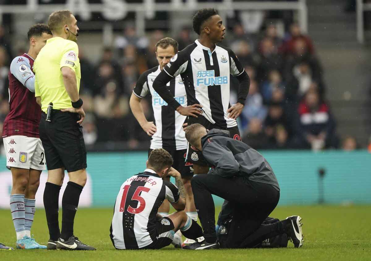 Newcastle United's Kieran Trippier receives treatment for an injury, during the English Premier League soccer match between Newcastle United and Aston Villa, at St. James' Park, in Newcastle, England, Sunday, Feb. 13, 2022. (Owen Humphreys/PA via AP)