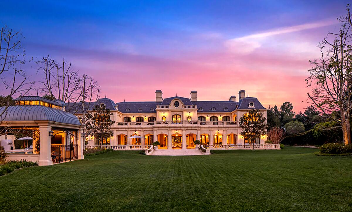 A mansion surrounded by an expansive lawn.